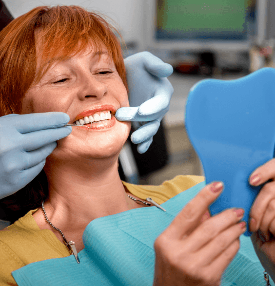 A woman sitting in a dentist chair, preparing for a dental examination in a clinical setting.