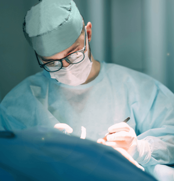 A surgeon performing dental surgery on a patient in a clinical setting, focused on the procedure.