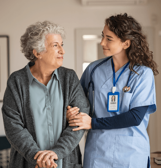 A nurse and an elderly woman stand together in a dentistry hallway, discussing dental care and treatment options.