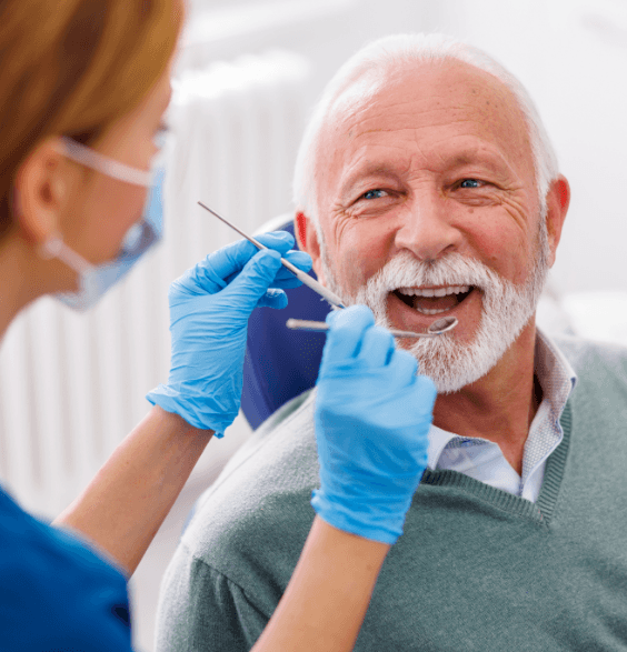 A man sitting in a dental chair, preparing for a dental examination in a clinical setting.