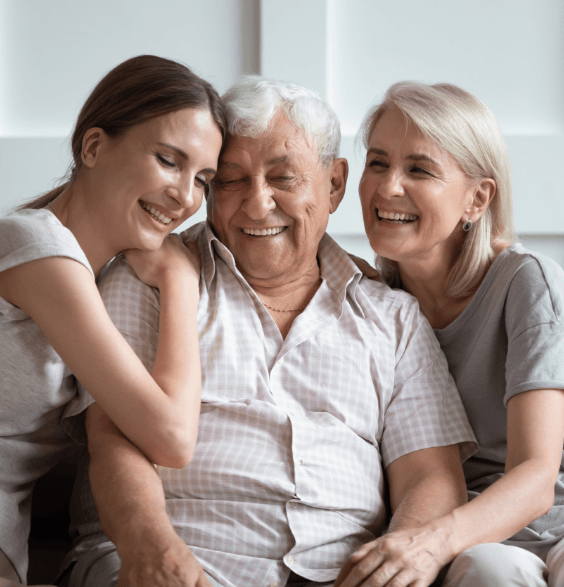 A woman and two men sitting on a couch, discussing dentistry topics in a casual setting.