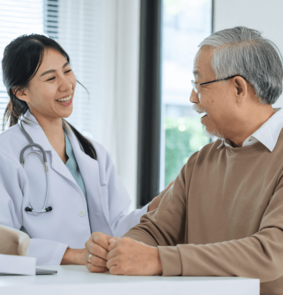 A dentist consulting with an Asian man about dental health and treatment options in a clinical setting.