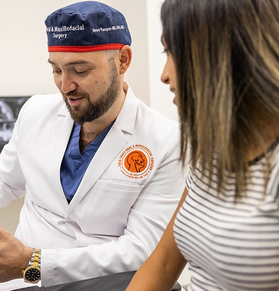 Oral surgeon talking to a patient about dental implants in Roslyn