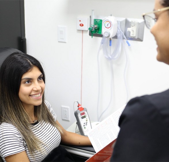 Woman in dental treatment chair smiling