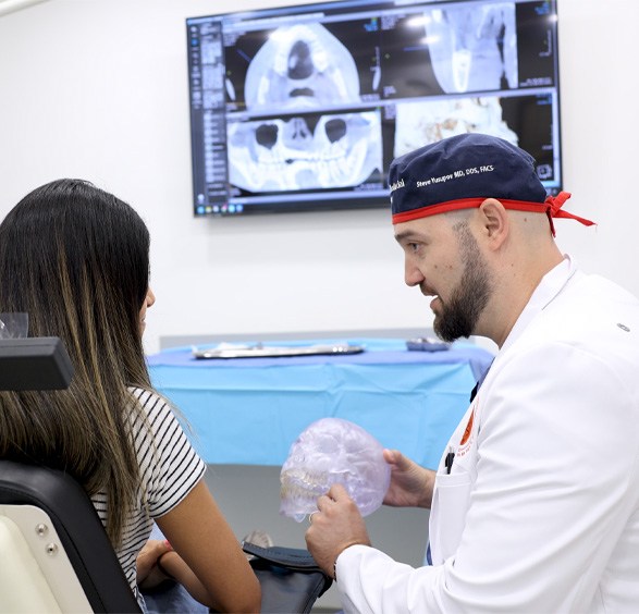 Dentist explaining how dental implants in Roslyn work to patient