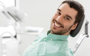 Man with dental implants in Roslyn, NY at dentist’s office