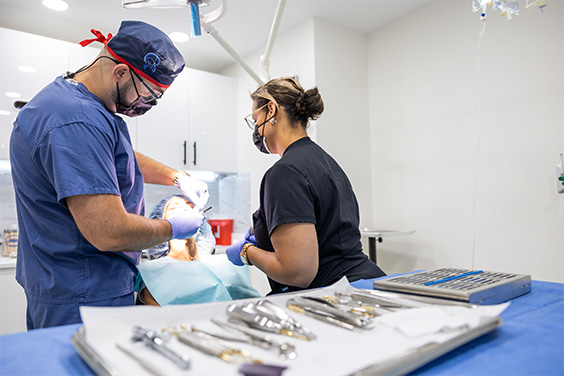 Oral surgeon and assistant treating a patient