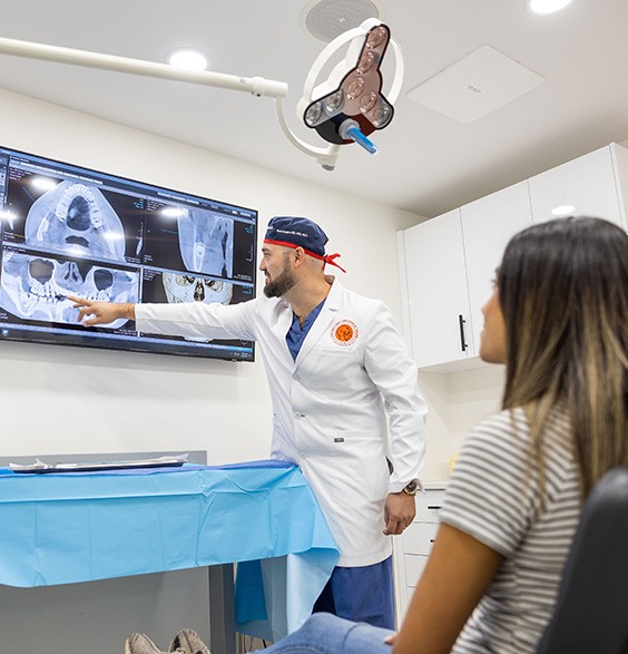 Oral surgeon showing a patient their dental x rays and why they need wisdom tooth extractions in Roslyn