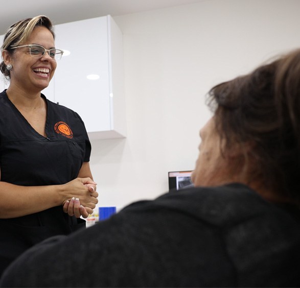 Smiling oral surgery team member talking to a patient